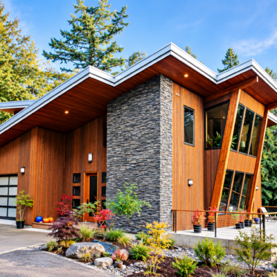 Pacific Northwest contemporary home featuring cedar siding, stacked stone, dramatic rooflines, and expansive windows.
